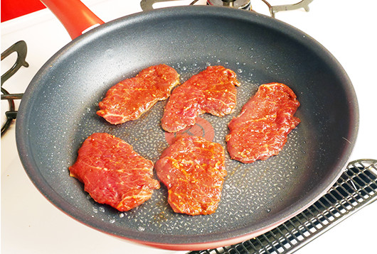 お肉をフライパンに1枚ずつ丁寧に並べ、やや強めの中火で表面を速やかに焼き固める