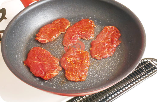 お肉をフライパンに1枚ずつ丁寧に並べ、やや強めの中火で表面を速やかに焼き固める